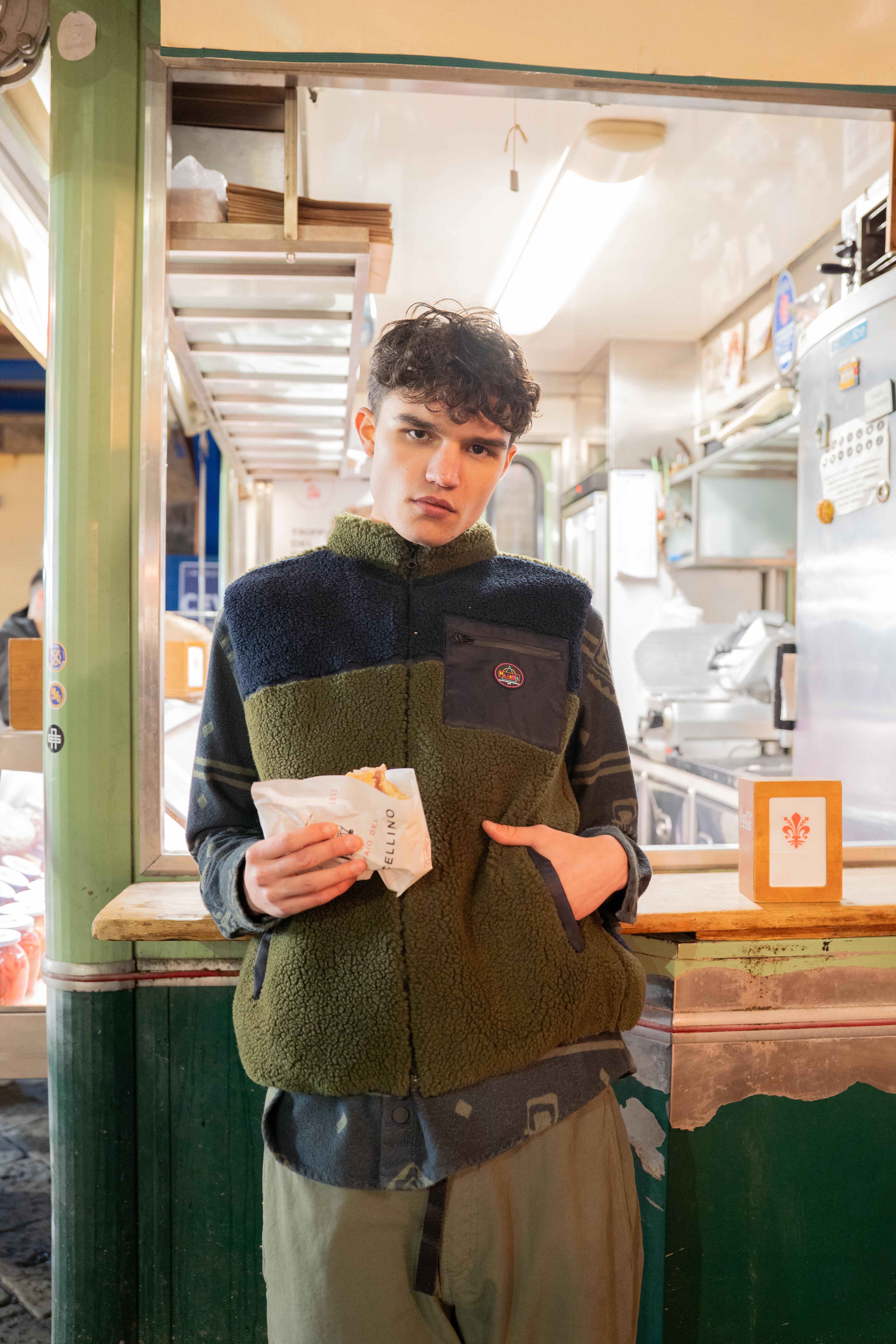 Shooting DIMA FW26: modello al café con gilet sherpa e camicia a pattern